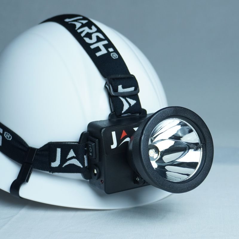 JHWL head torch beside a safety helmet