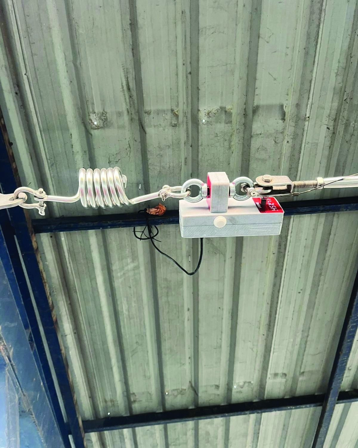 LineAlert installed inline on a working fixed line next to the spring shock absorber