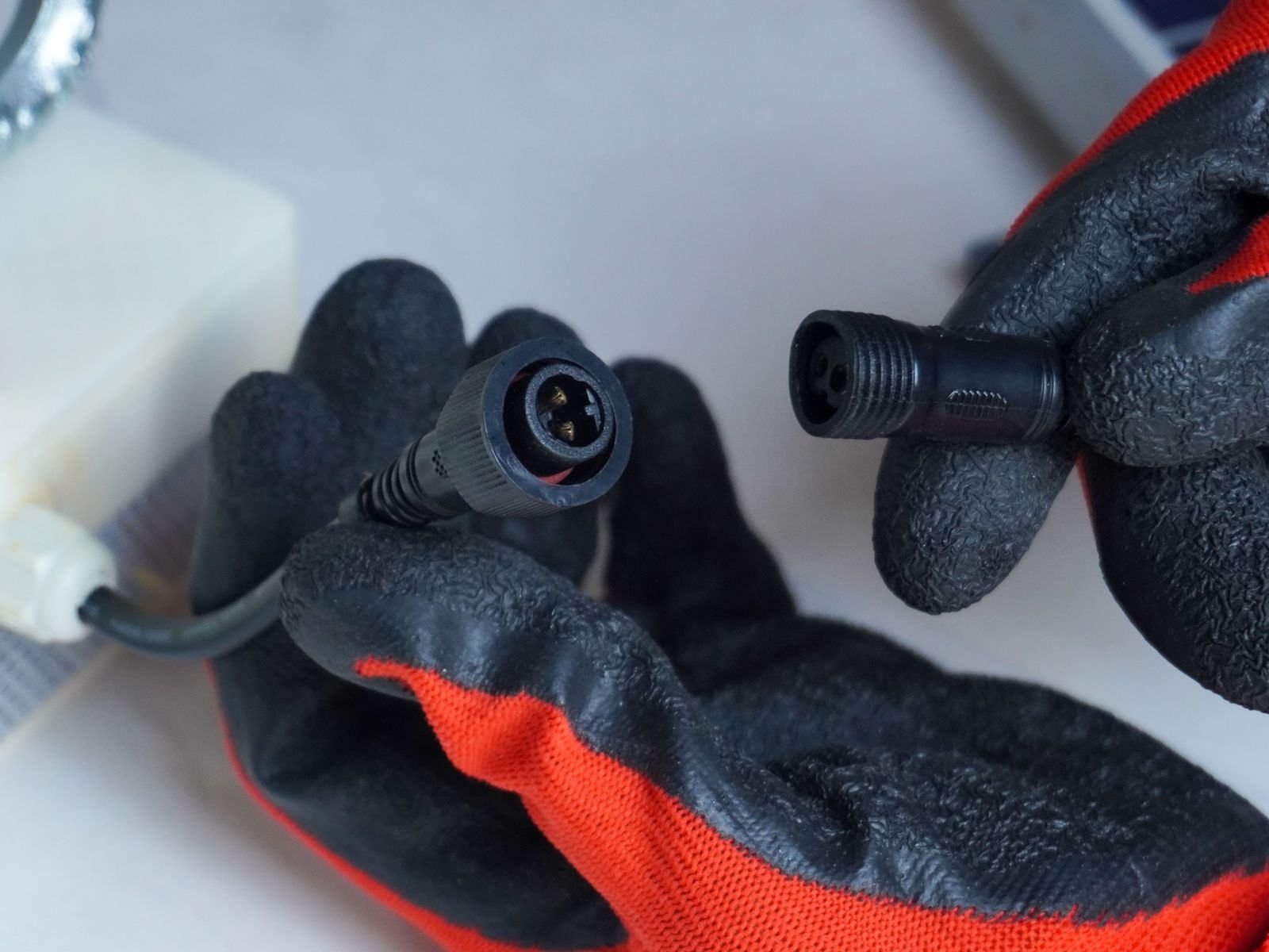 Gloved hands connecting the solar cable to LineAlert