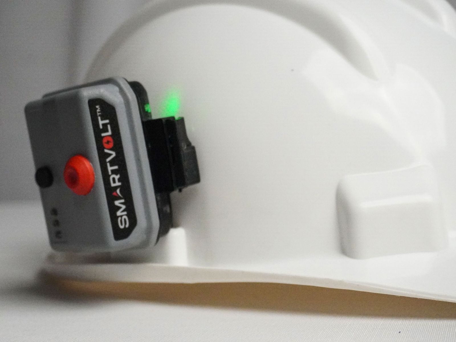 SmartVolt clipped to the side of a white safety helmet